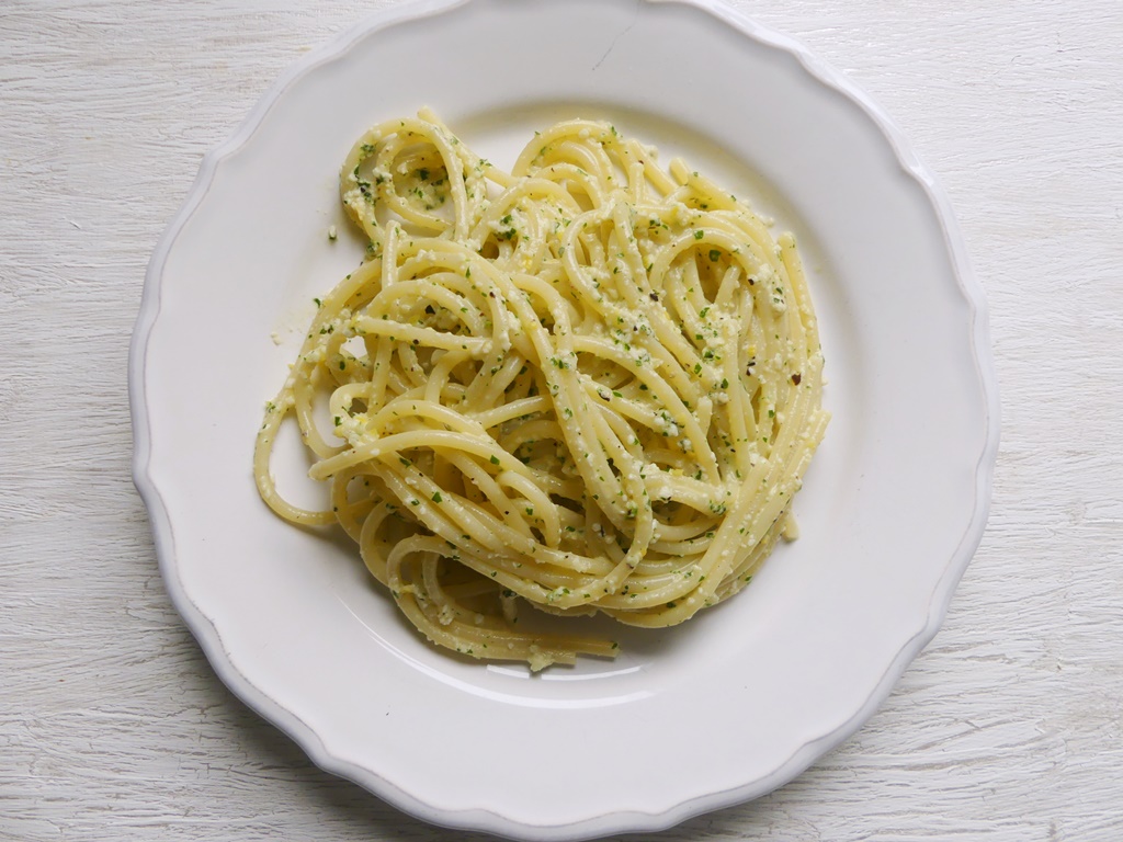 Ein weißer Teller mit Spaghetti und Zitronenpesto